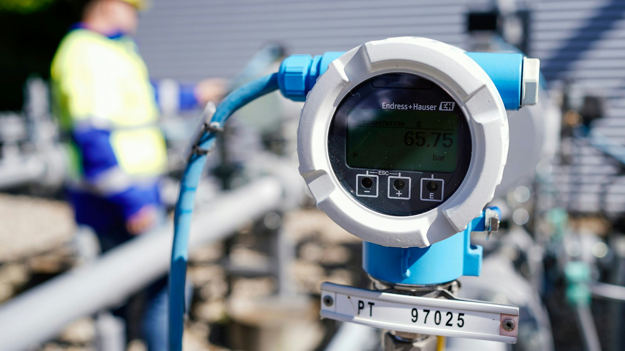 Ein Mitarbeiter steht auf dem Gelände des Gasspeichers in Frankenthal hinter einem Druckmessgerät.