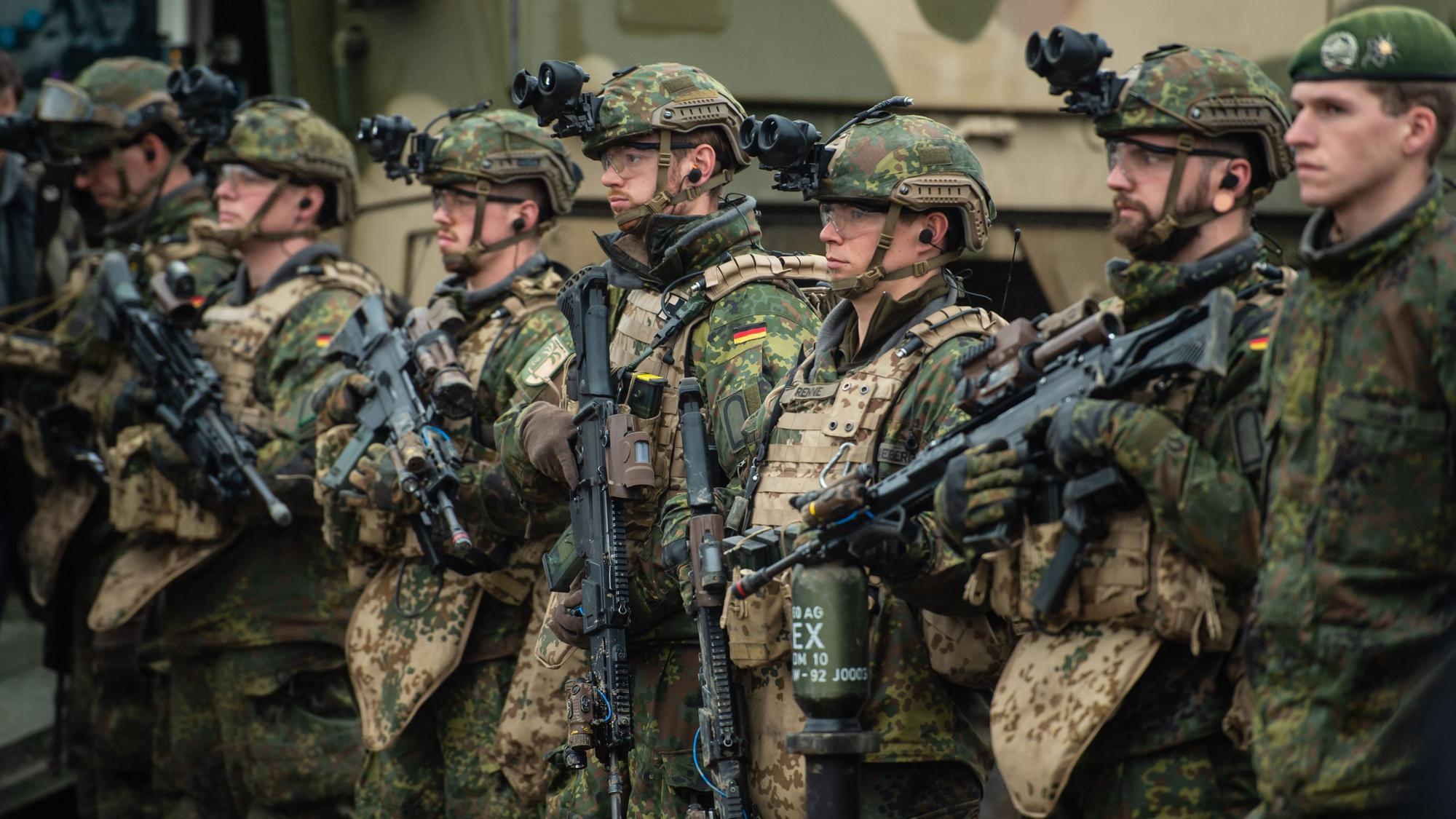 Soldaten der Bundeswehr stehen bei einer Übung im Gelände in der Lüneburger Heide.