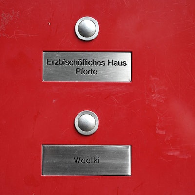 Ein Klingelschild mit dem Namen Woelki und ein Schild mit der Aufschrift "erzbischöfliches Haus Pforte"