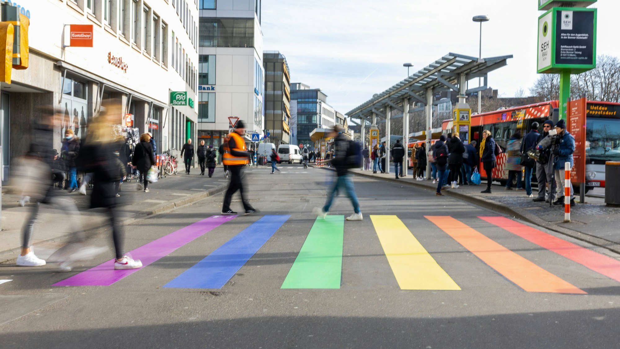Mehrere Personen stehen auf dem bunten Zebrastreifen in Regenbogenfarben in Bonn.