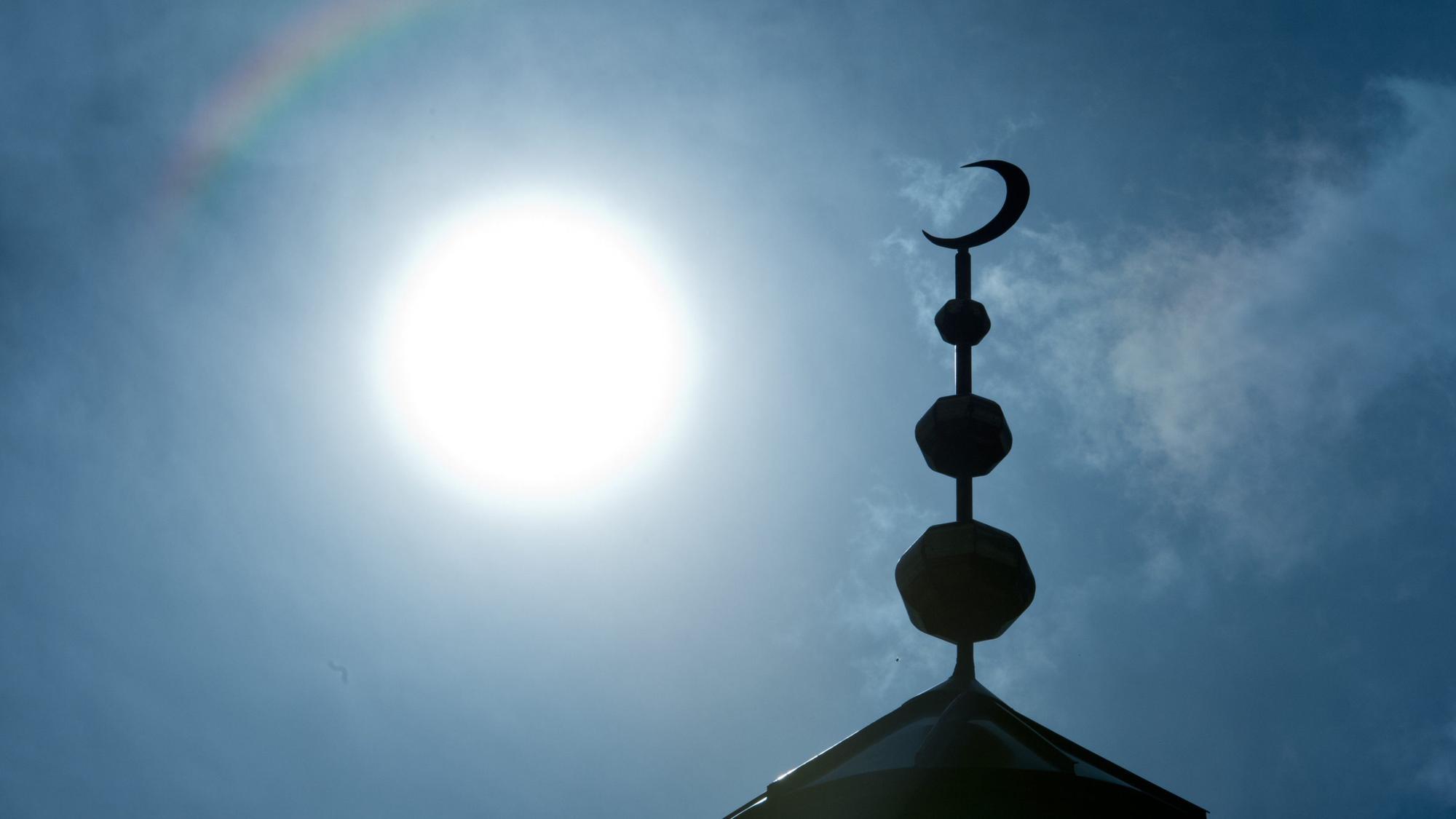 Frankfurt/Main: Der Halbmond auf dem Minarett der Abubakr-Moschee hebt sich als Schattenriss vor der Sonne ab.