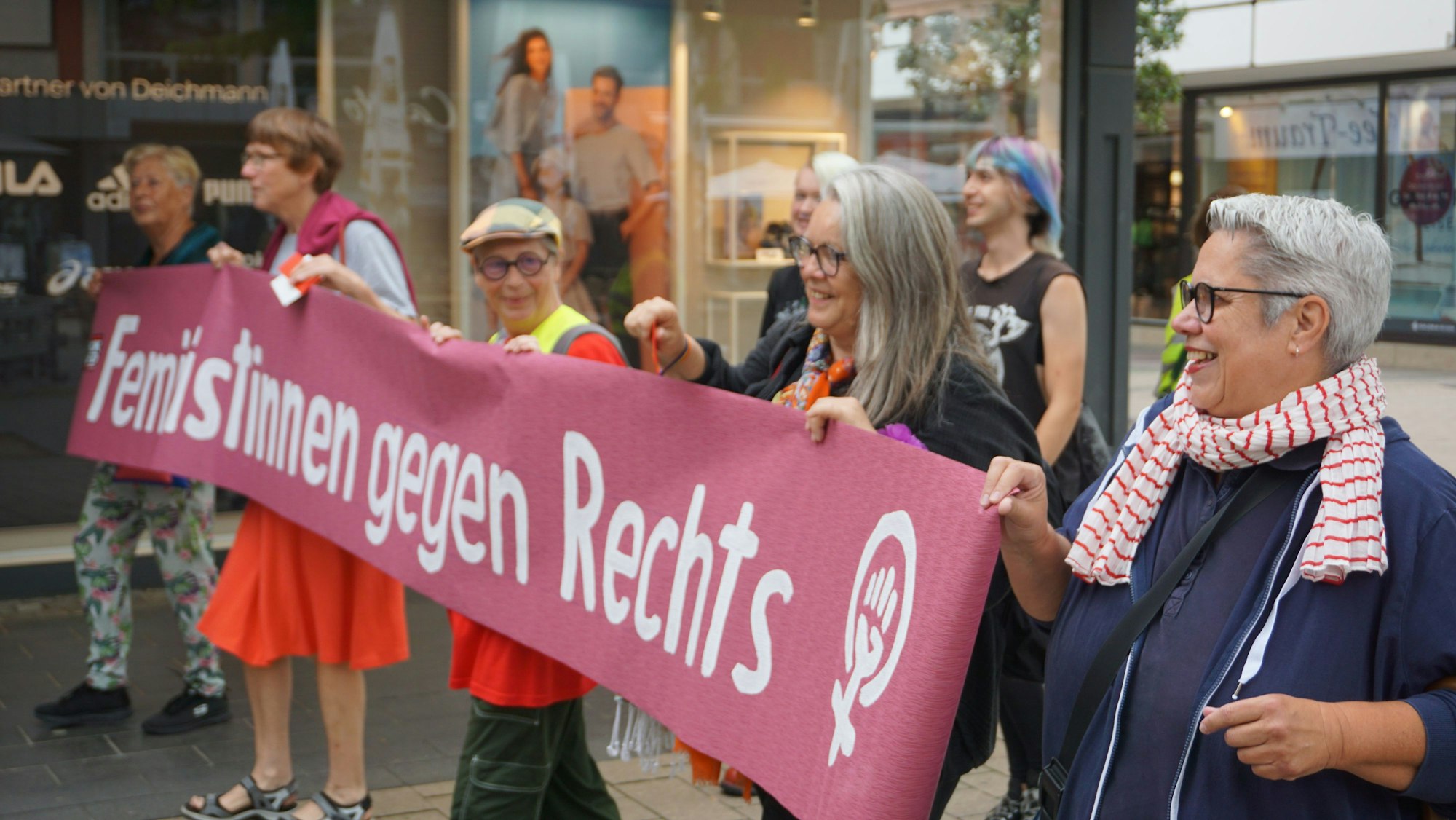 Fünf Frauen halten ein rotes Banner mit der Aufschrift: „Feministinnen gegen Rechts“.