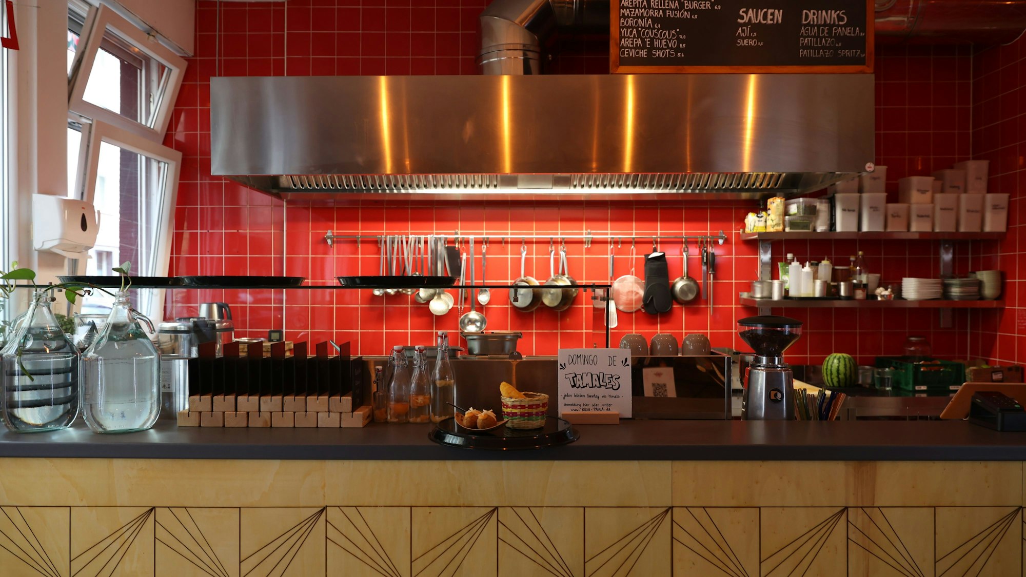 Eine Küchenzeile mit roten Fliesen und vielen Gewürzen