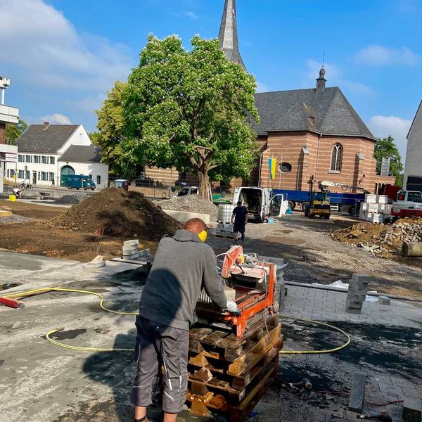 Arbeiter tragen Kies und Sand auf während der Bauarbeiten am Carl-Schurz-Platz