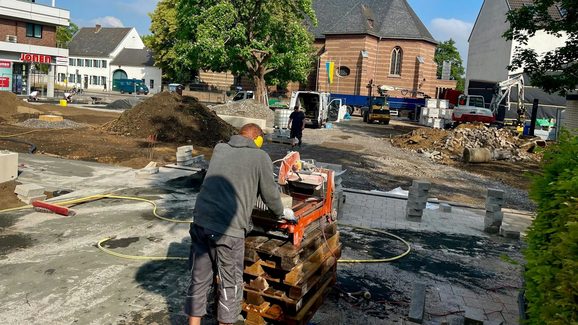 Arbeiter tragen Kies und Sand auf während der Bauarbeiten am Carl-Schurz-Platz