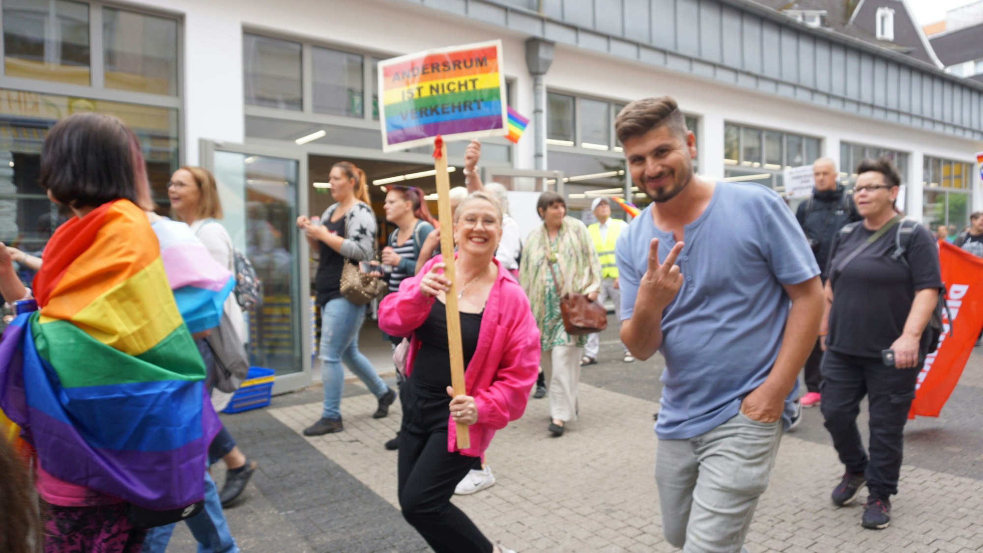 Eine Frau läuft inmitten einer Demonstration. Sie hält ein Schild mit der Aufschrift „Andersrum ist nicht verkehrt“ in die Kamera.