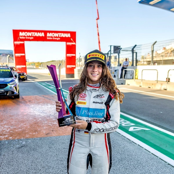 Rennfahrerin Carrie Schreiner hält den Siegerpokal in ihren Händen.