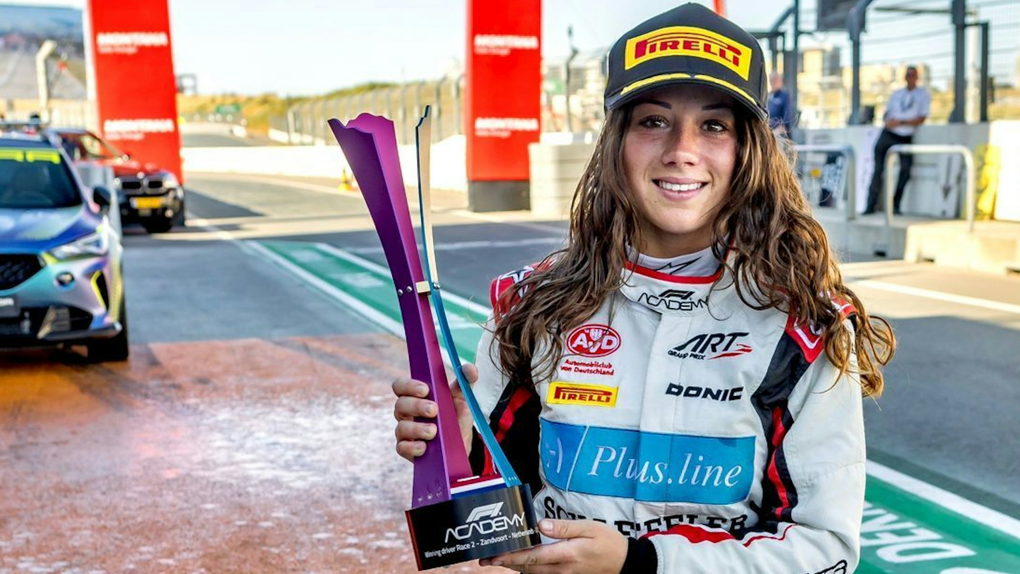 Rennfahrerin Carrie Schreiner hält den Siegerpokal in ihren Händen.