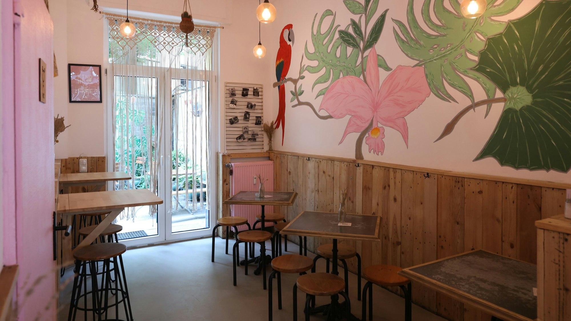 Der Innenraum eines Restaurants, an der Wand ein Bild mit Blumen und einem Papagei