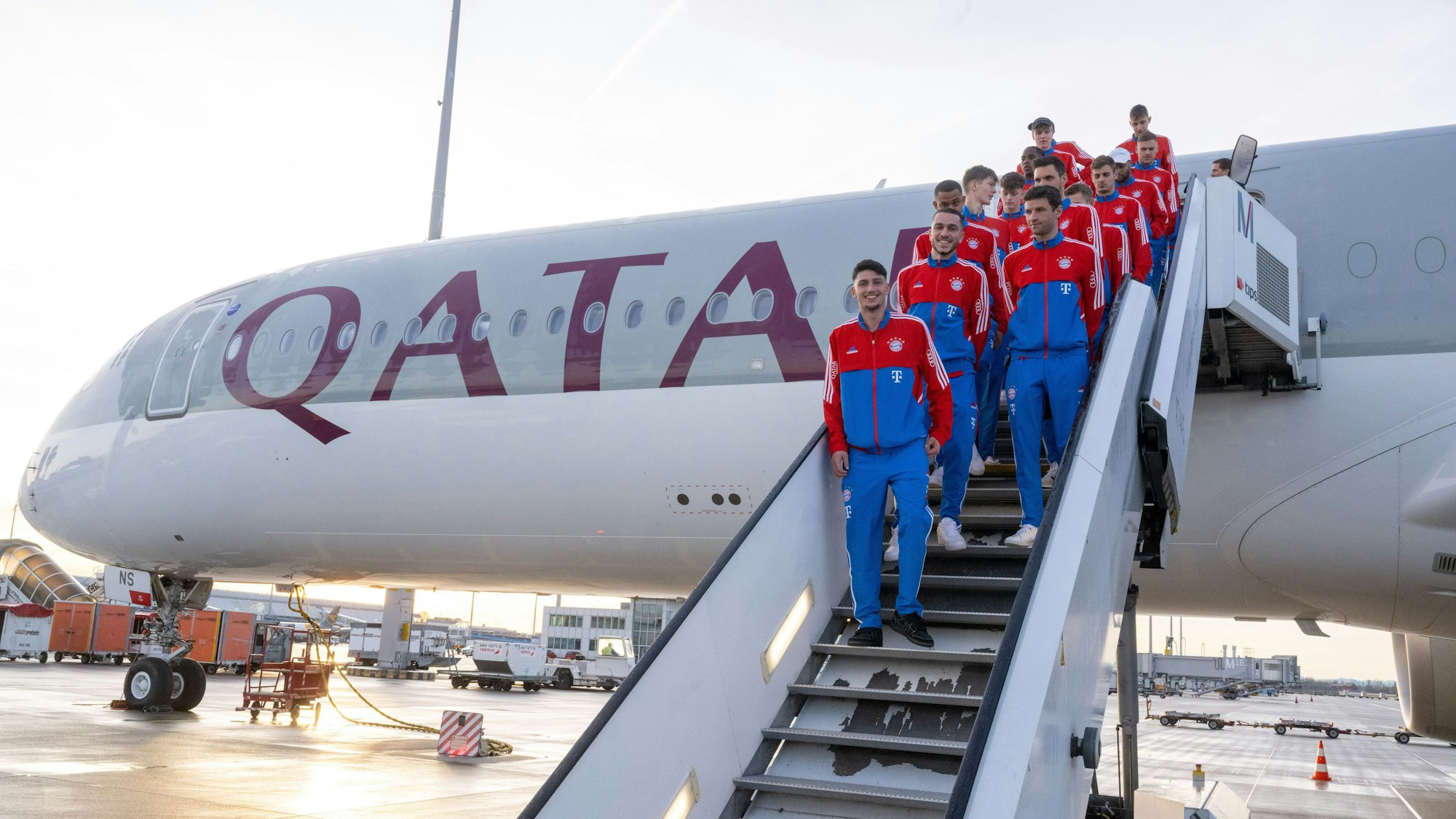 Die Spieler des deutschen Fußball-Bundesligisten FC Bayern München stehen auf der Treppe eines Flugzeugs der Fluglinie Qatar Airways auf dem Münchner Flughafen vor der Abreise ins Trainingslager nach Doha in Katar.