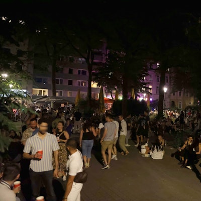 Eine große Gruppe junger Menschen sitzt auf dem Brüsseler Platz.