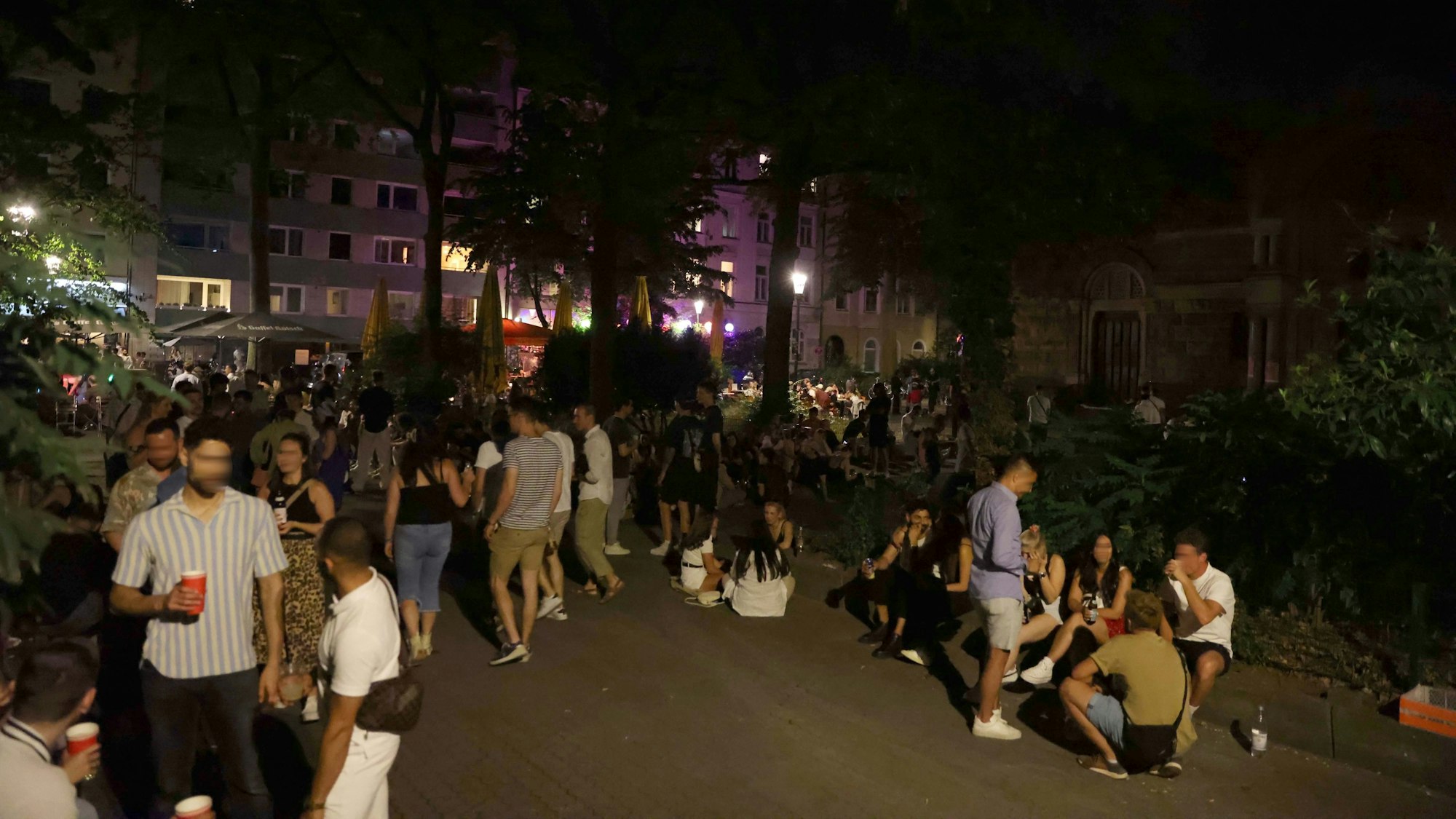 Nachtschwärmer stehen und sitzen am Brüsseler Platz