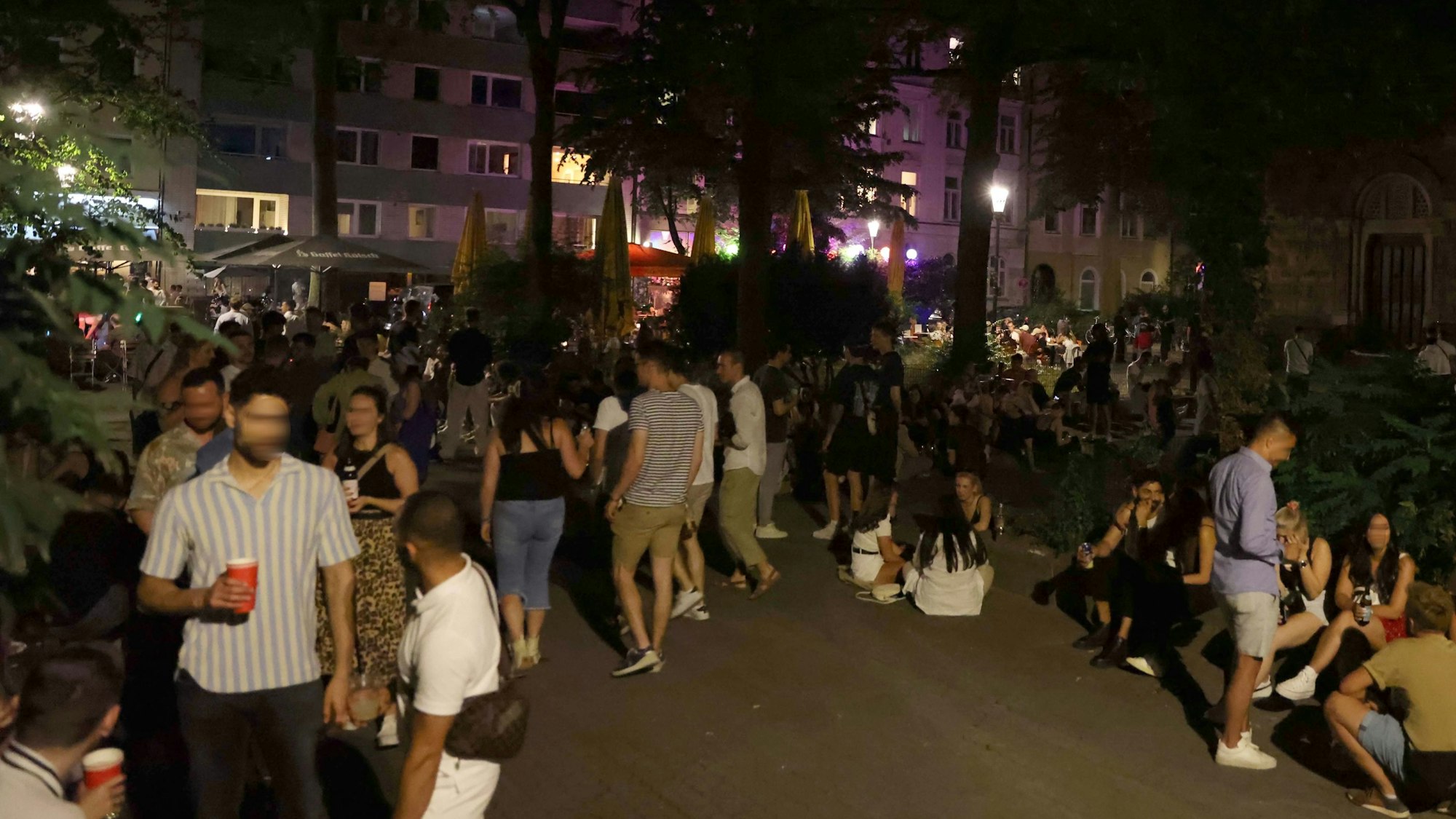 Eine große Gruppe junger Menschen sitzt auf dem Brüsseler Platz.