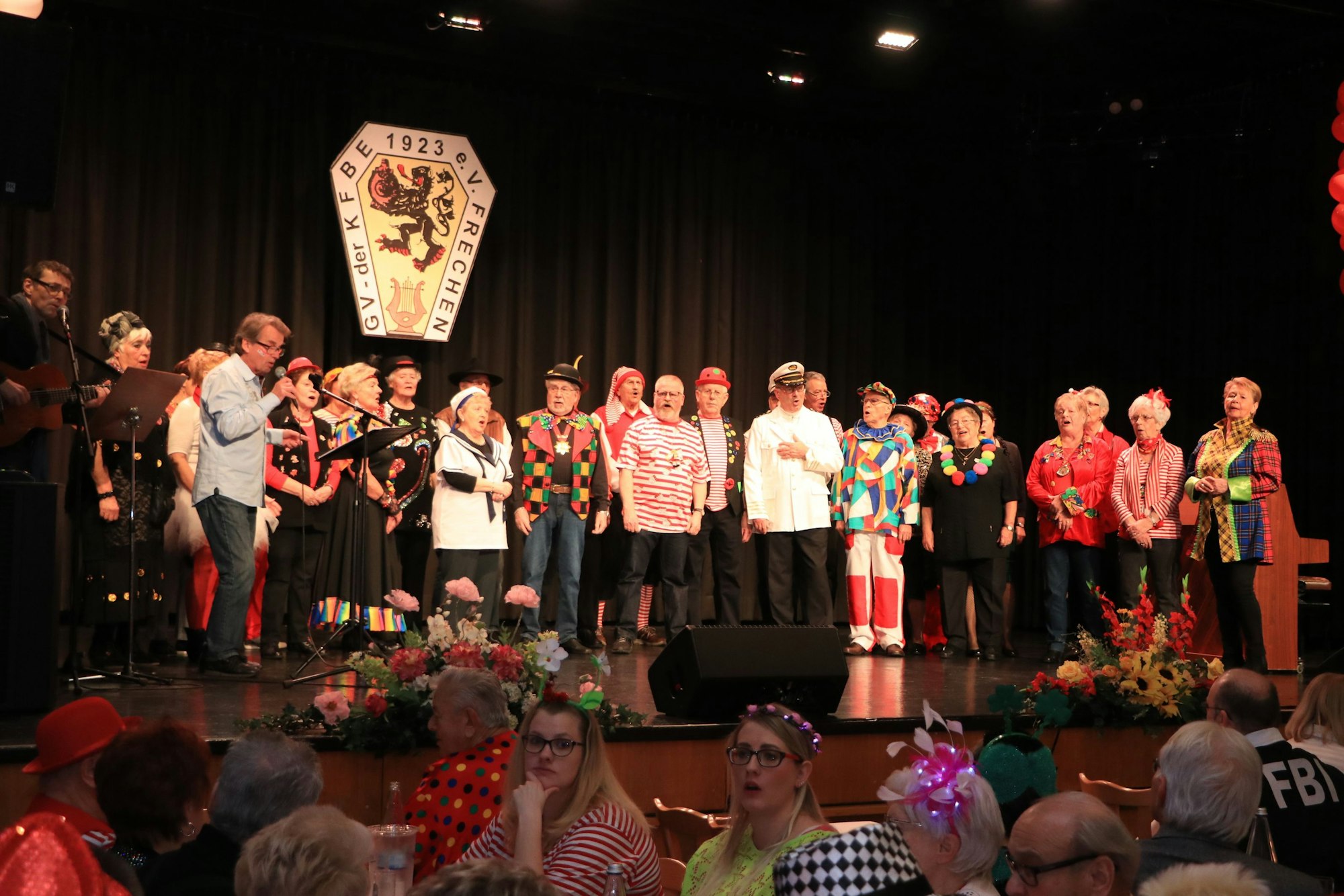 Sängerinnen und Sänger stehen auf einer Bühne.