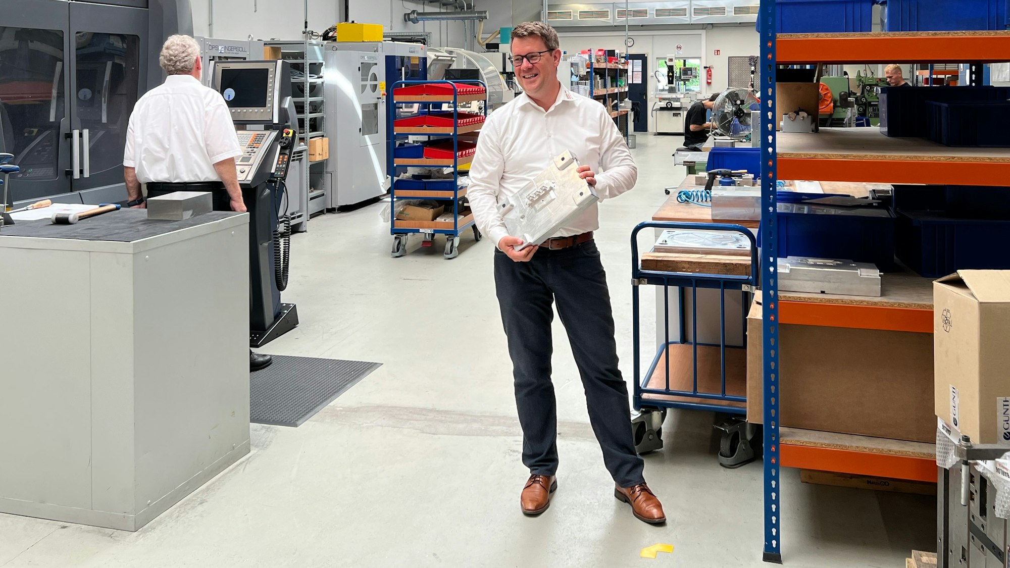 Der Overather Unternehmer Peter Barlog steht im Vordergrund, der Gründer hält sich im Hintergrund.