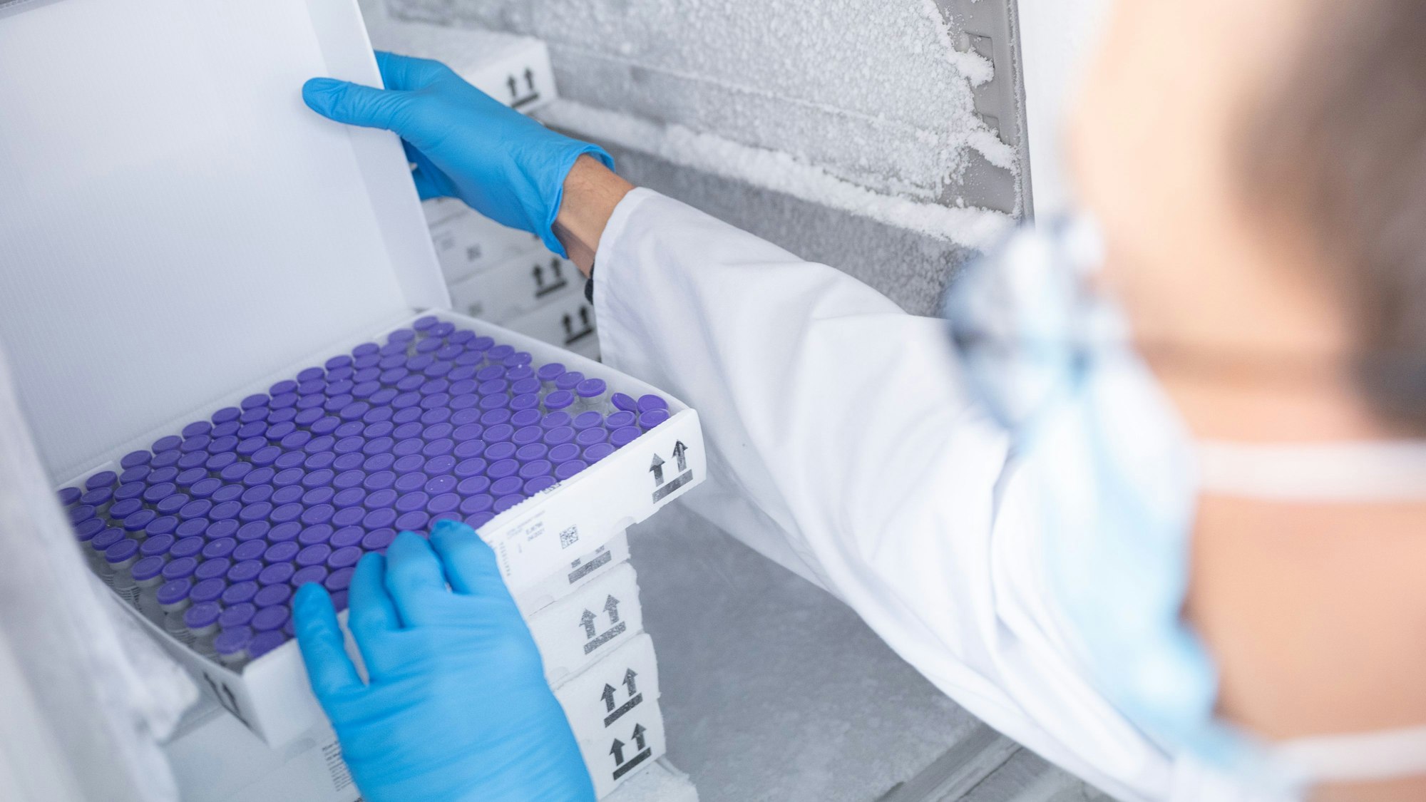 Ein Arzt öffnet einen Karton mit Impfstoff-Ampullen, die in einem Gefrierschrank gelagert sind. (Symbolbild) In den USA klagt eine Hochschule gegen eine Reinigungsfirma, weil deren Mitarbeiter den Strom abgeschaltet und dadurch wichtige Forschungszellen zerstört haben soll.