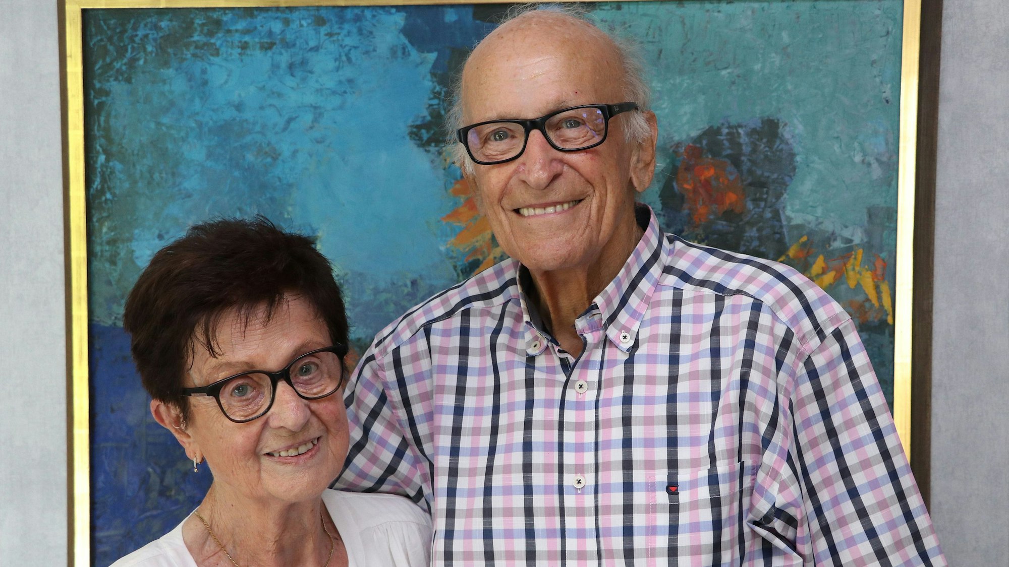 Eine Frau und ein Mann stehen vor einem Bild.