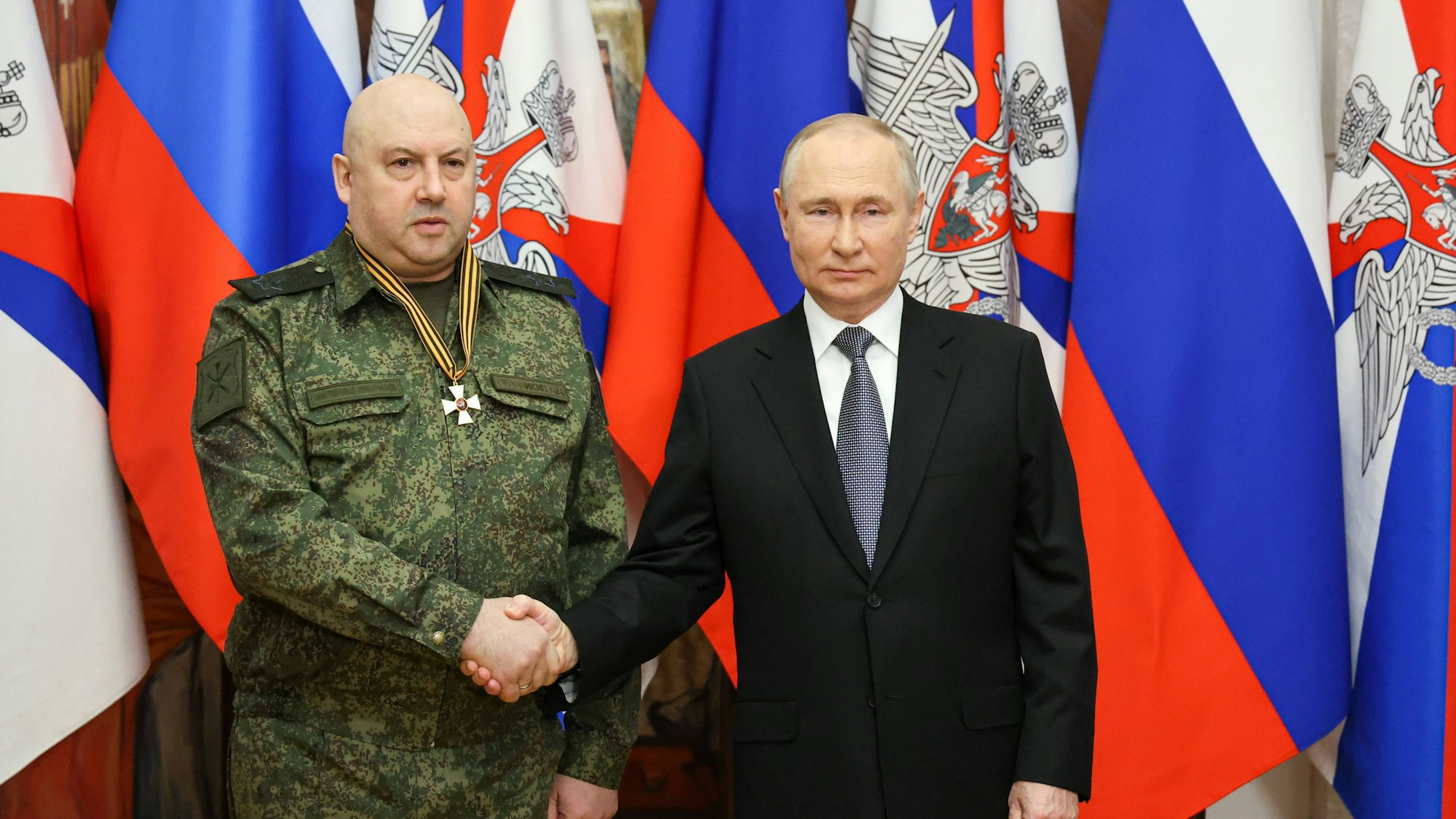 General Surowikin und Wladimir Putin schütteln sich die Hände.