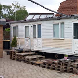 Ein Übergangshaus, vor dem Paletten stehen.