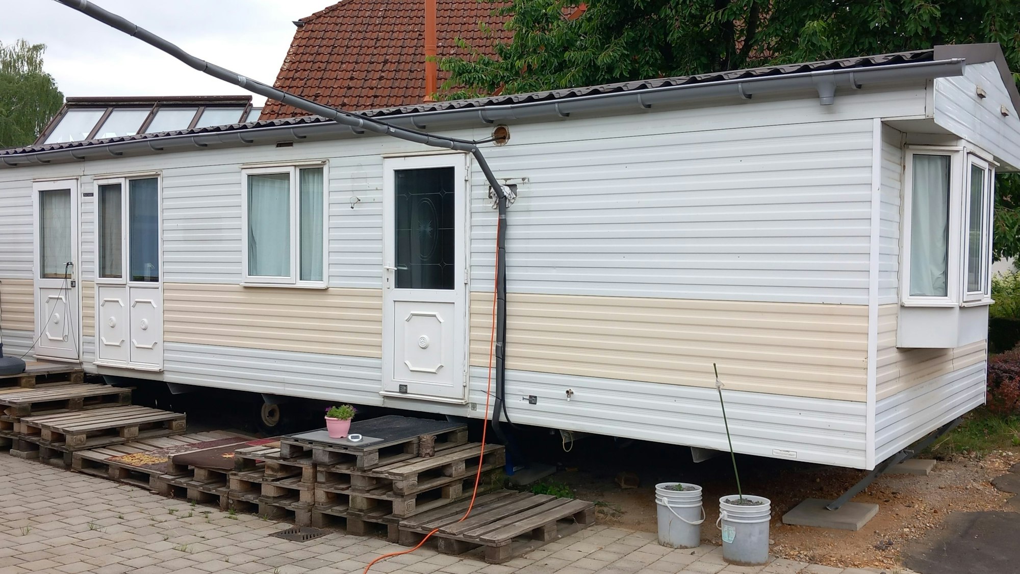 Ein Übergangshaus, vor dem Paletten stehen.