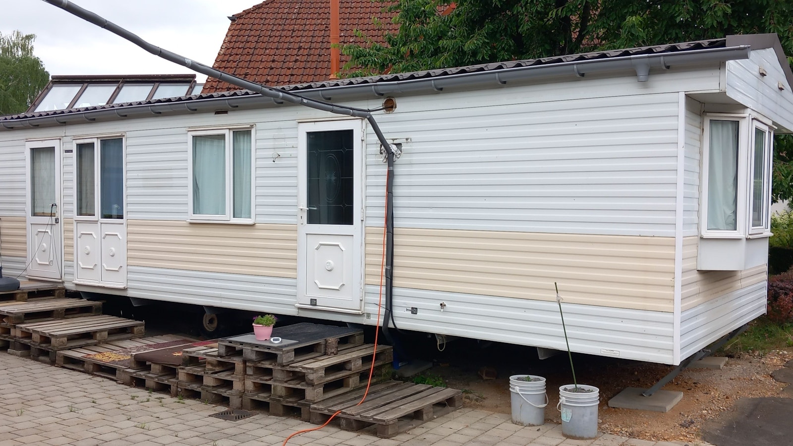 Ein Übergangshaus, vor dem Paletten stehen.