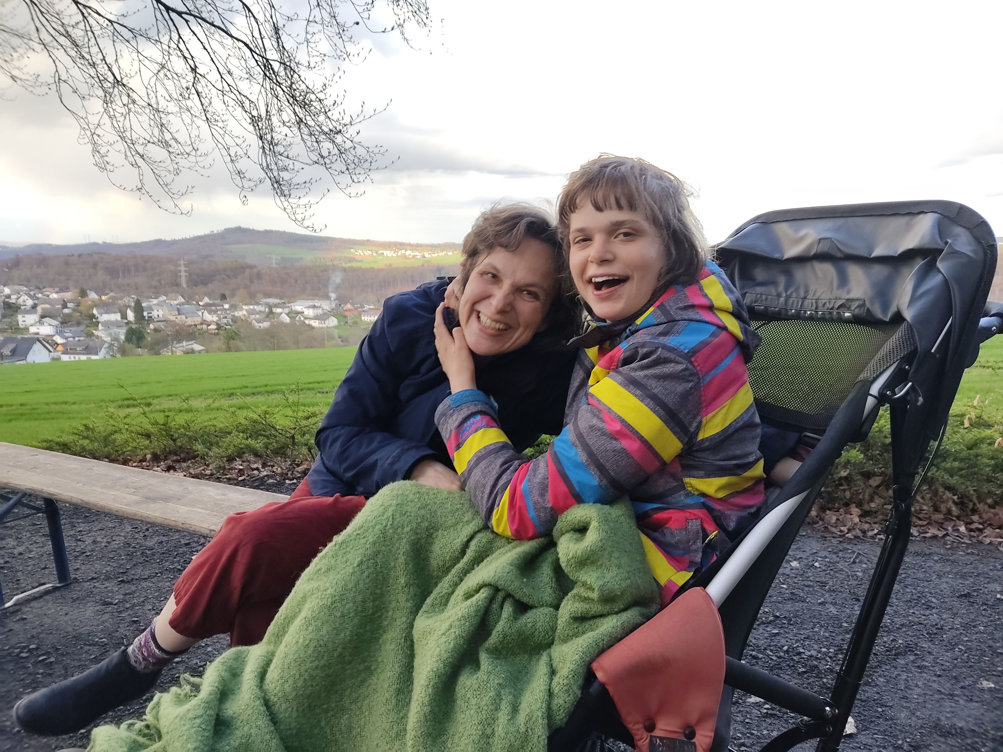 Das Bild zeigt Mutter und Tochter, die sich gut gelaunt umarmen.