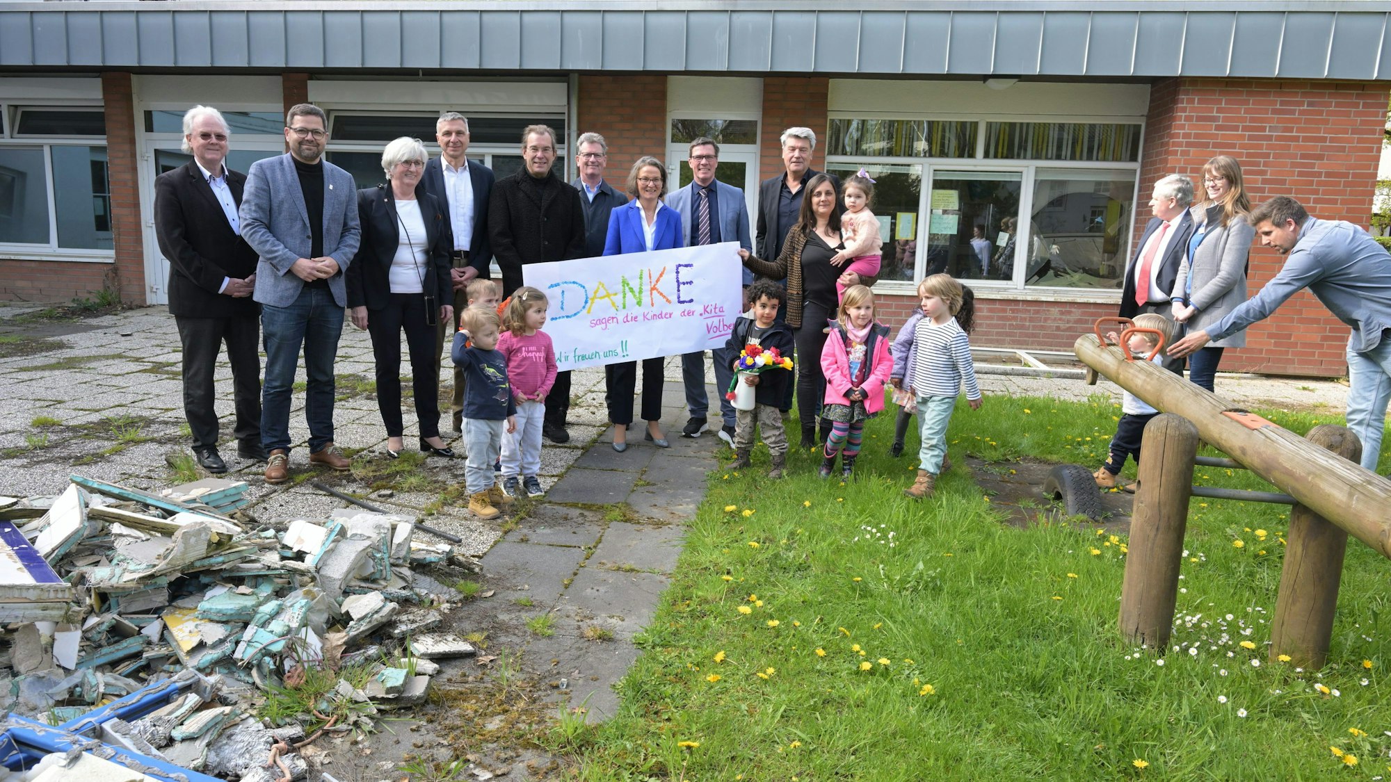 Kinder, Erwachsene und die Ministerin stehen vor der Kita.