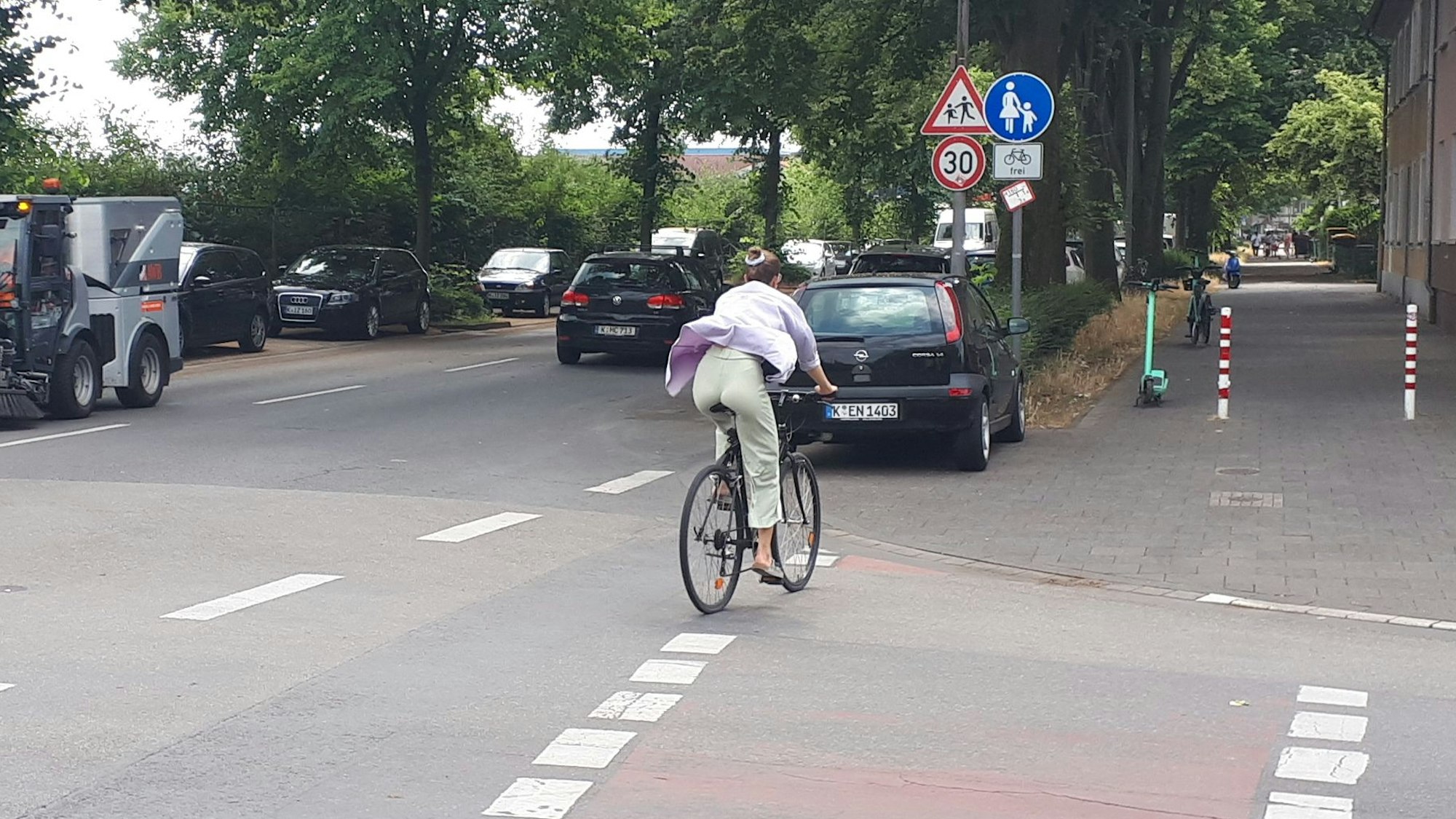 Ein Radfahrer wechselt von der Straße auf den Radfahrstreifen auf dem Gehweg.