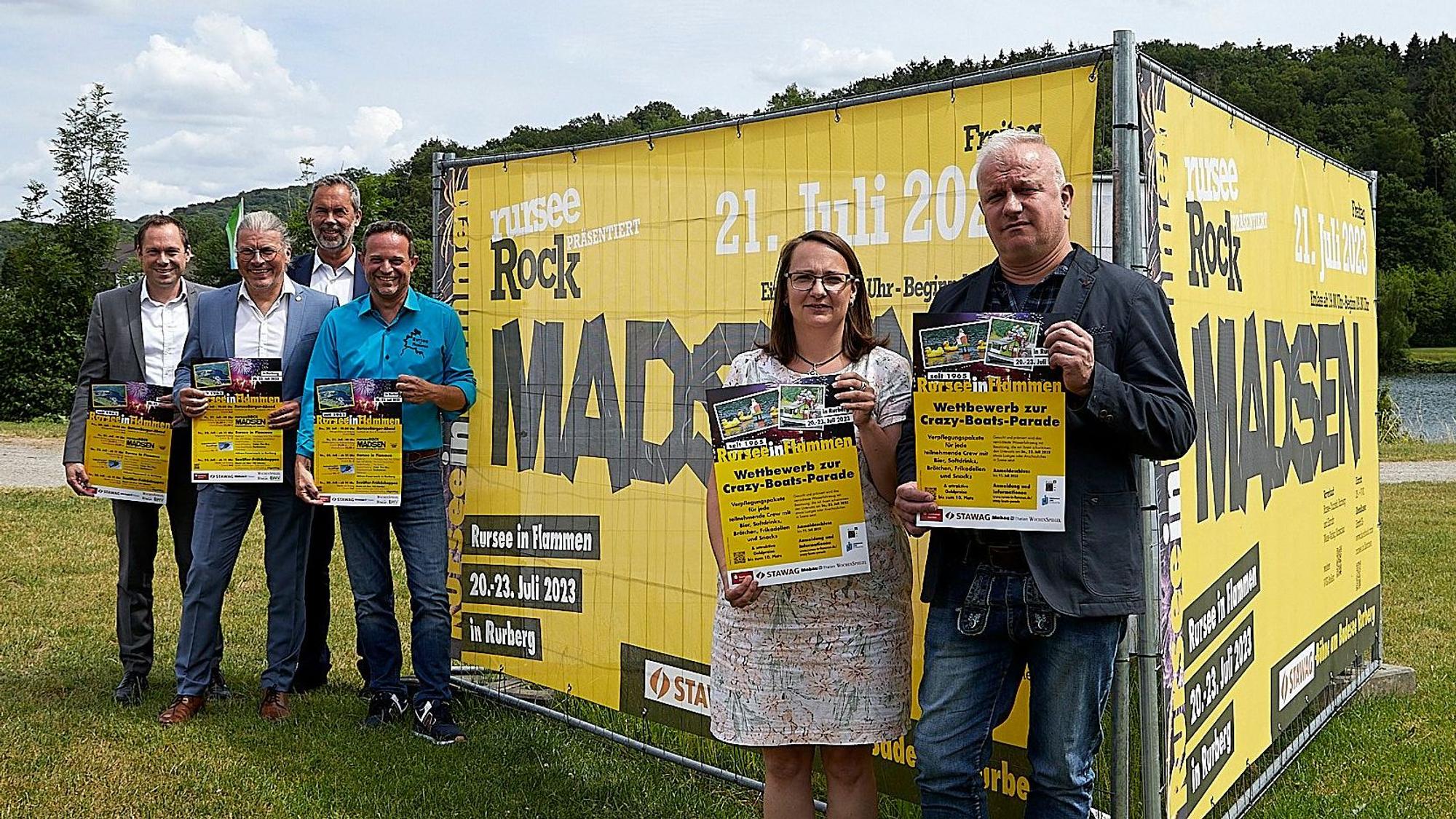 Auf einer Wiese vor dem Rursee stehen die Veranstalter von „Rursee in Flammen“ und präsentieren das diesjährige Programm.