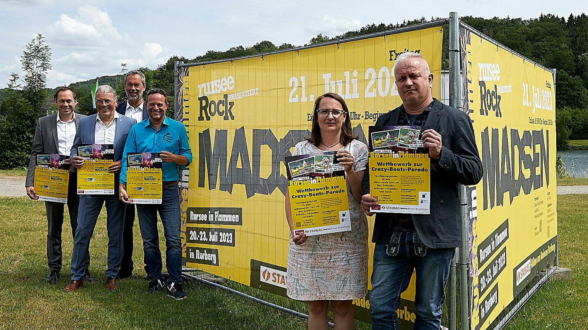 Auf einer Wiese vor dem Rursee stehen die Veranstalter von „Rursee in Flammen“ und präsentieren das diesjährige Programm.