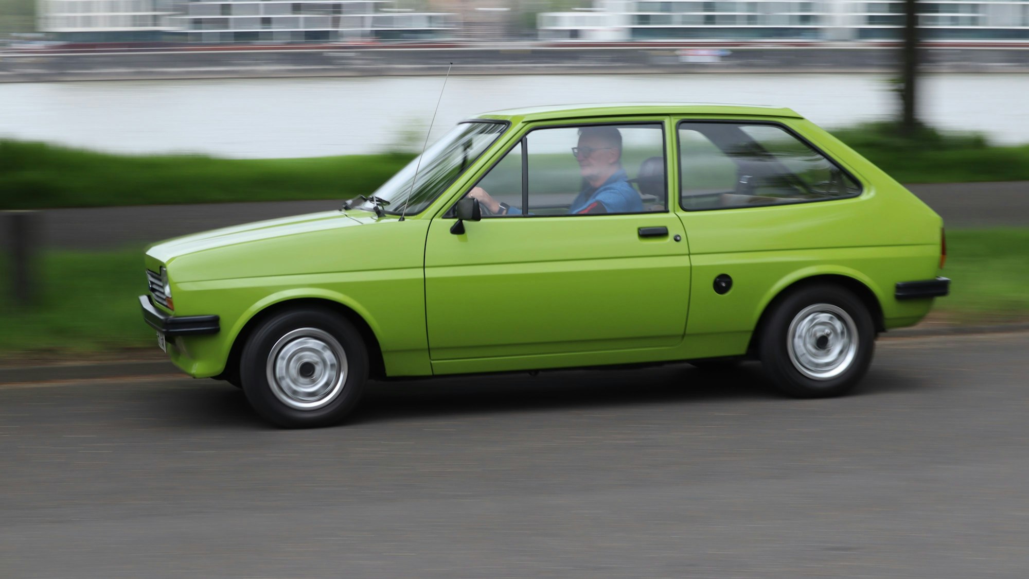 Ein grüner Ford Fiesta fährt auf der Straße.