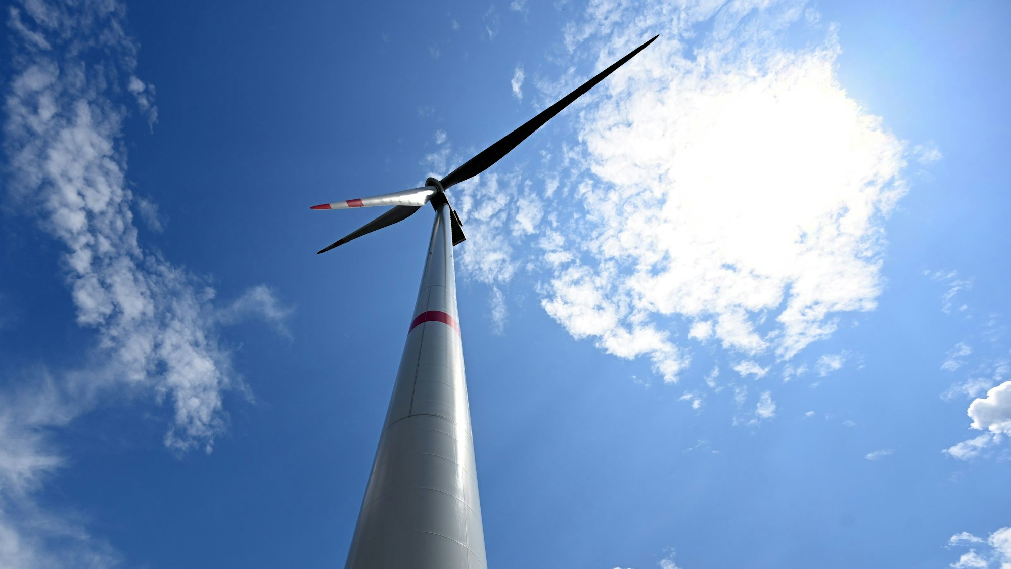 Wolken ziehen über Windräder zur Stromerzeugung.