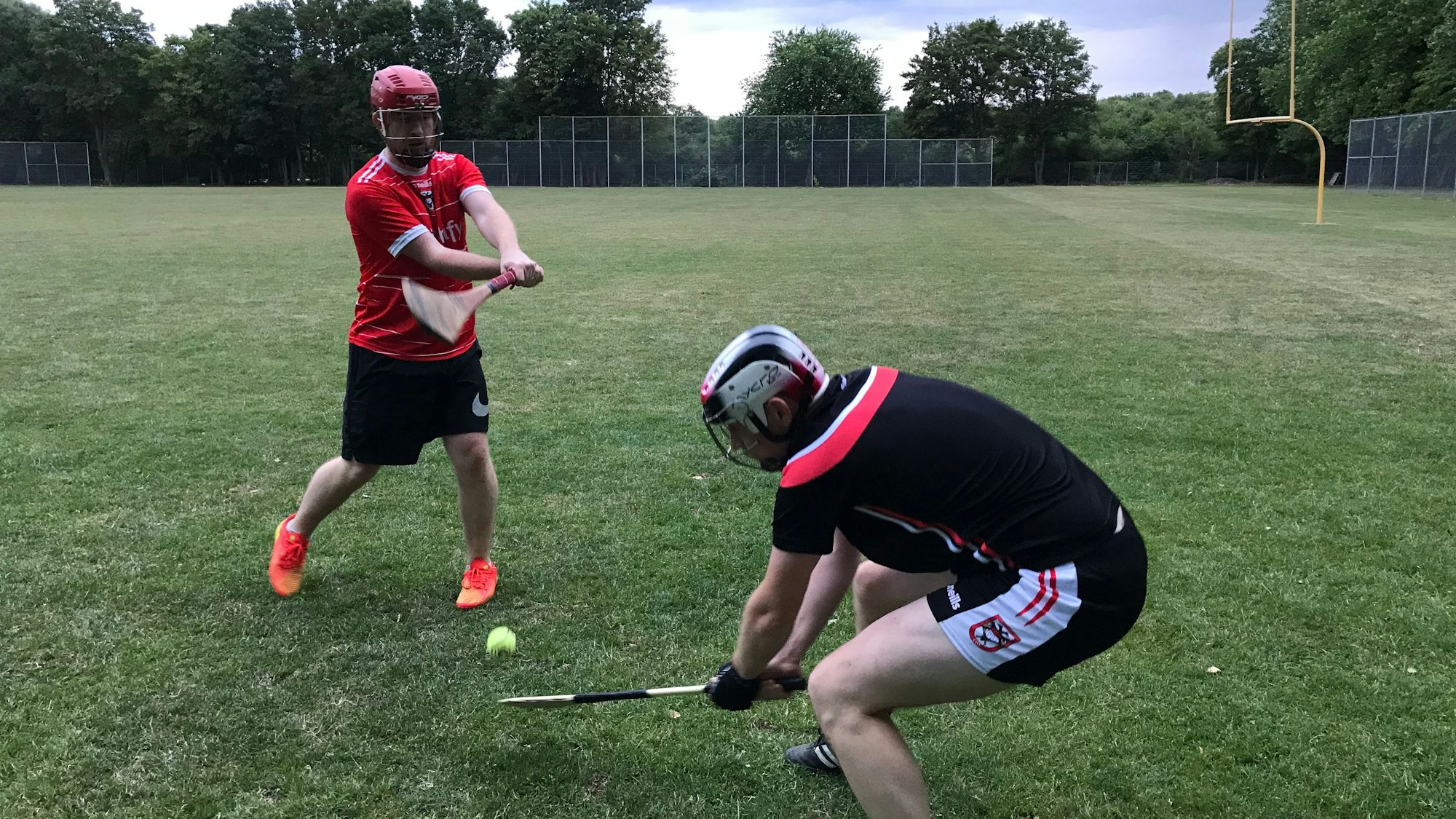 Zwei Spieler kämpfen mit ihren Hurling-Schlägern um den Ball.