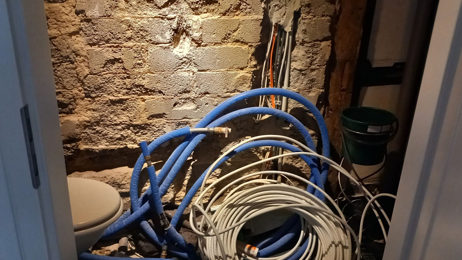 Im künftigen Badezimmer türmen sich Schläuche der unterschiedlichen Heizungsanlagen.