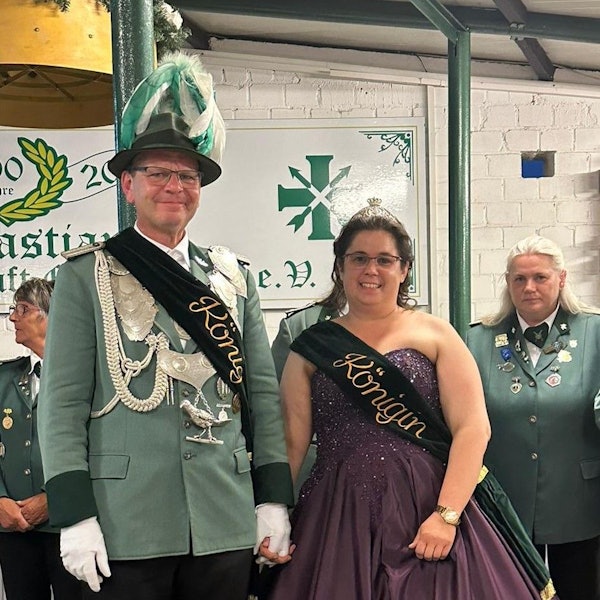 Das Foto zeigt einen Mann in Schützenuniform und eine Frau im Ballkleid, beide mit Schärpe.