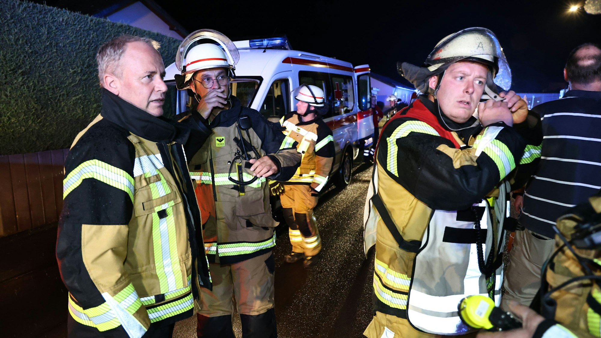 Der Bürgermeister in einer Einsatzjacke lässt sich von den Feuerwehrleuten informieren.
