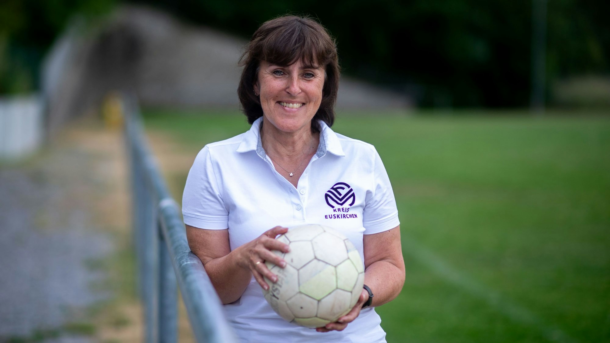 Doris Mager lehnt an eine Absperrstange und hält einen Ball in ihren Händen.