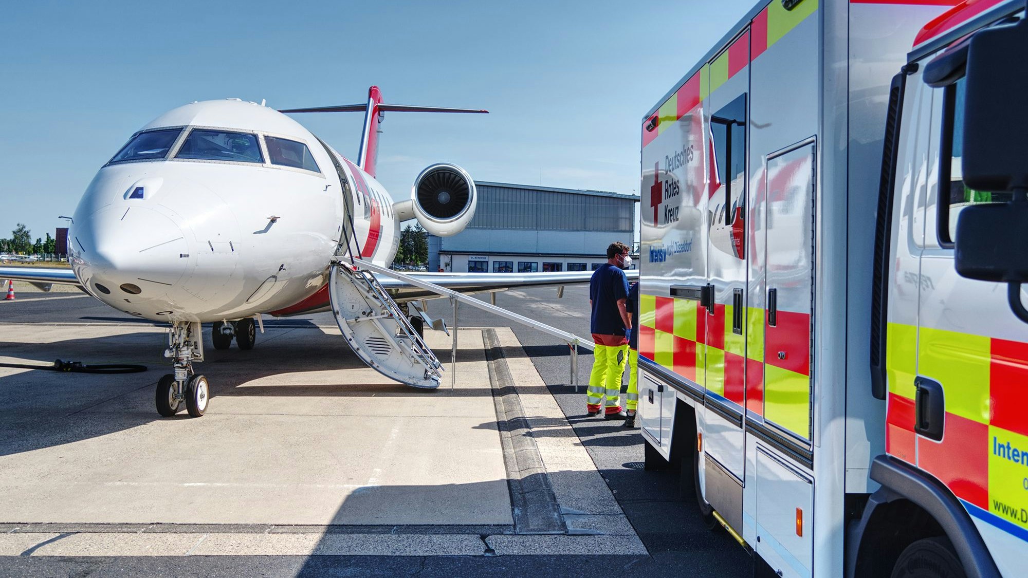 Ein Krankenwagen steht vor einem Flugzeug.