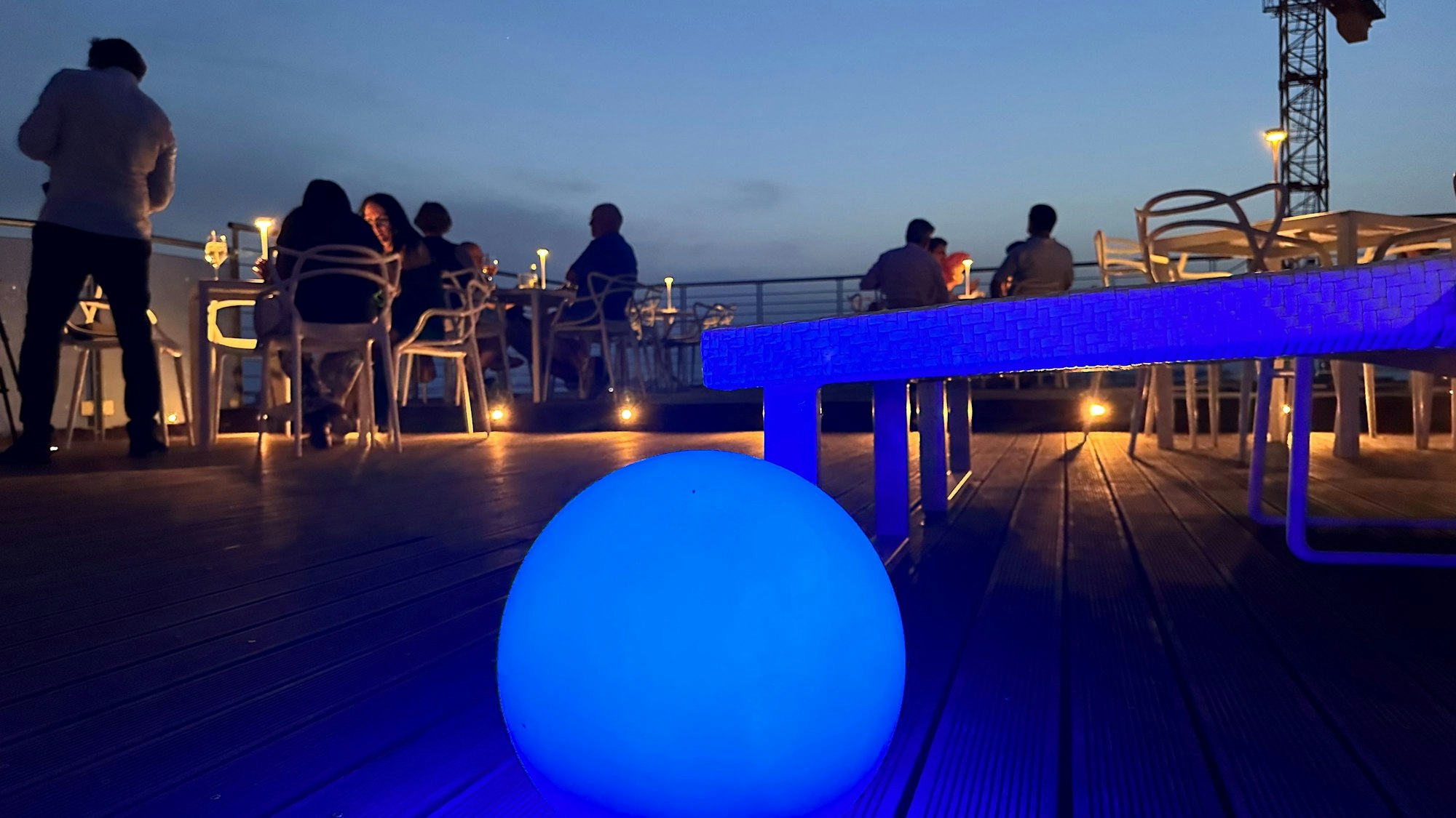 Eine Dachterrasse wird in ein blaues Licht gehüllt.