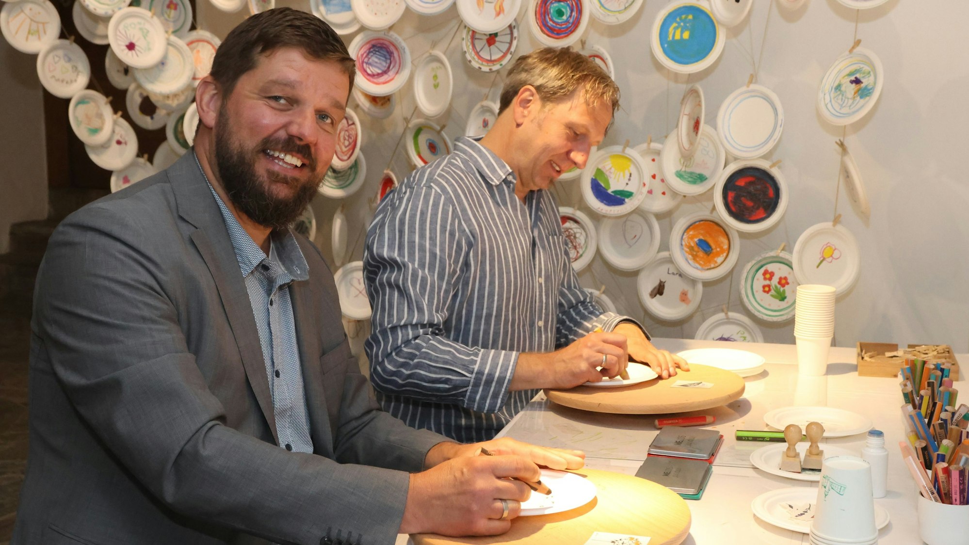 Felix Ammann und Steffen Müller bemalen Teller.