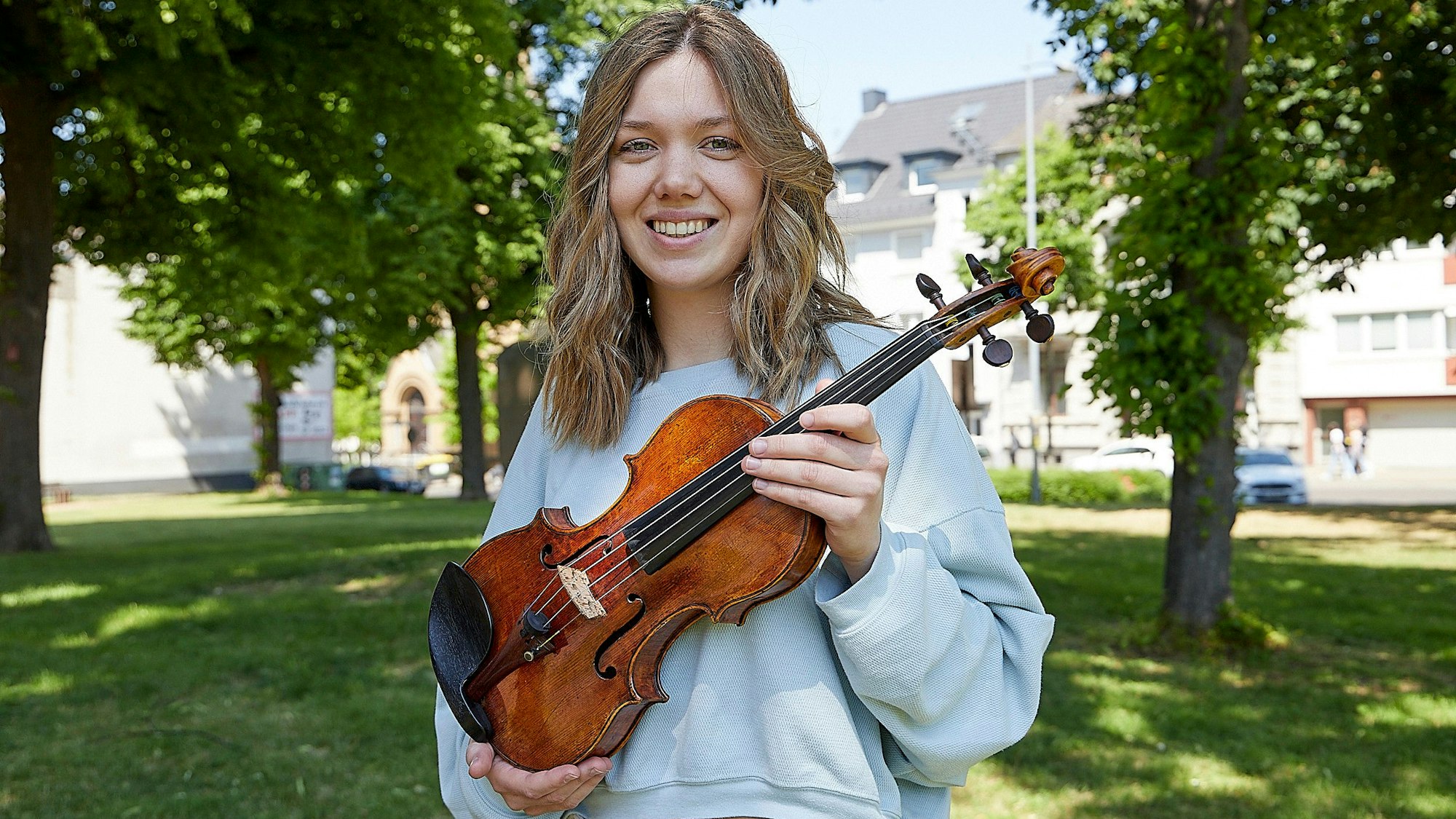 Die Geigerin Judith Stapf hält ihr Instrument in den Händen.