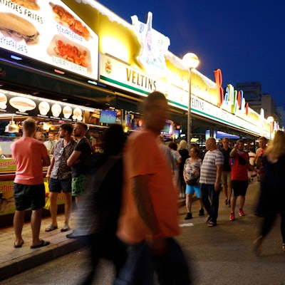 Menschen gehen an der Bar Bamboleo in der Bierstraße am Ballermann vorbei.