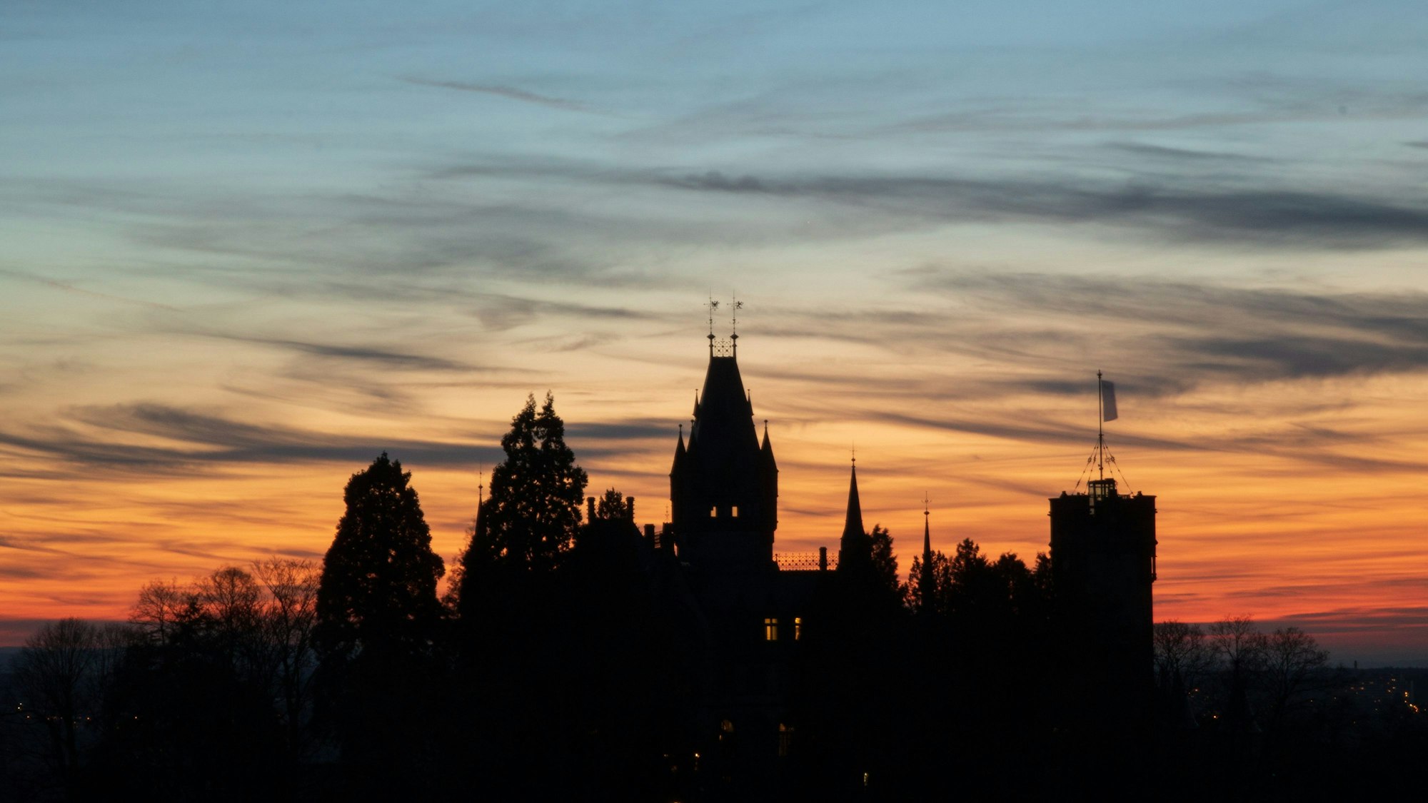 Der Drachenfels mit der Drachenburg im Sonnenuntergang.