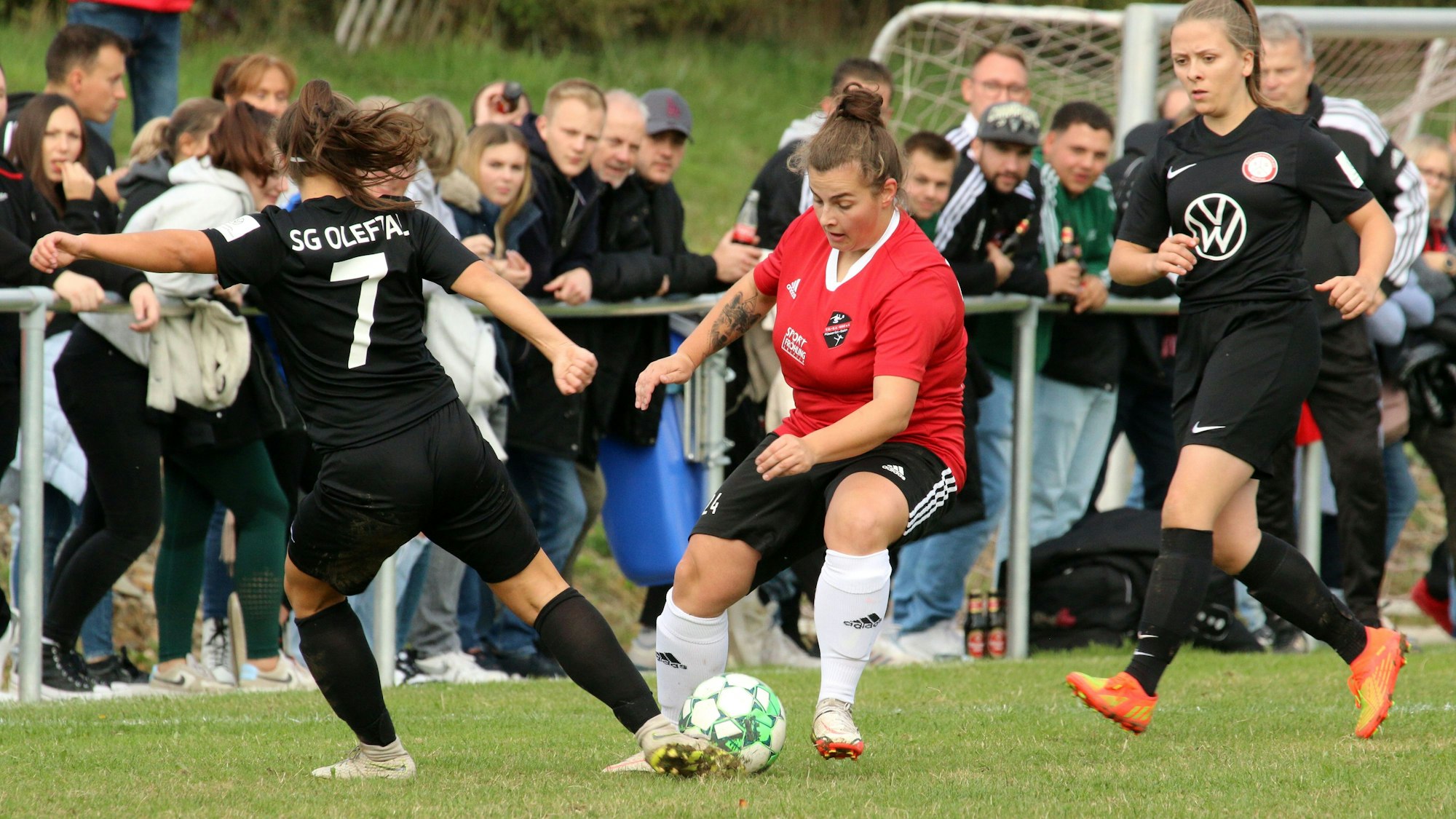 Spielerinnen der SG Oleftal und des TB-SV Füssenich-Geich kämpfen vor großer Zuschauerkulisse um den Ball.