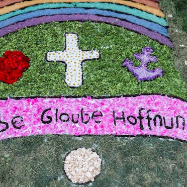 Die Wörter „Liebe, Glaube, Hoffnung“ sind zu lesen in einem Blumenteppich.