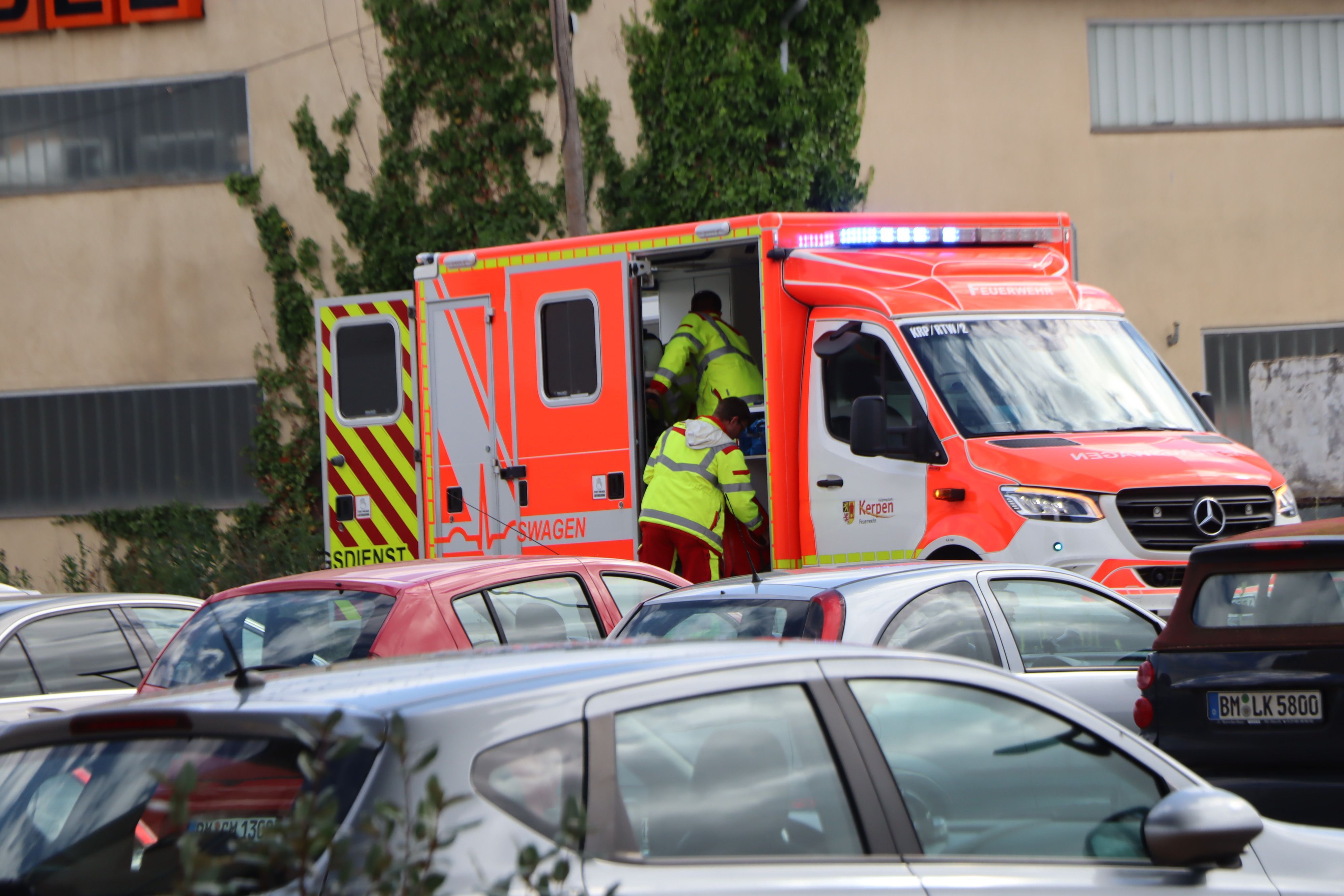 Einsatzkräfte steigen in einen Rettungswagen.