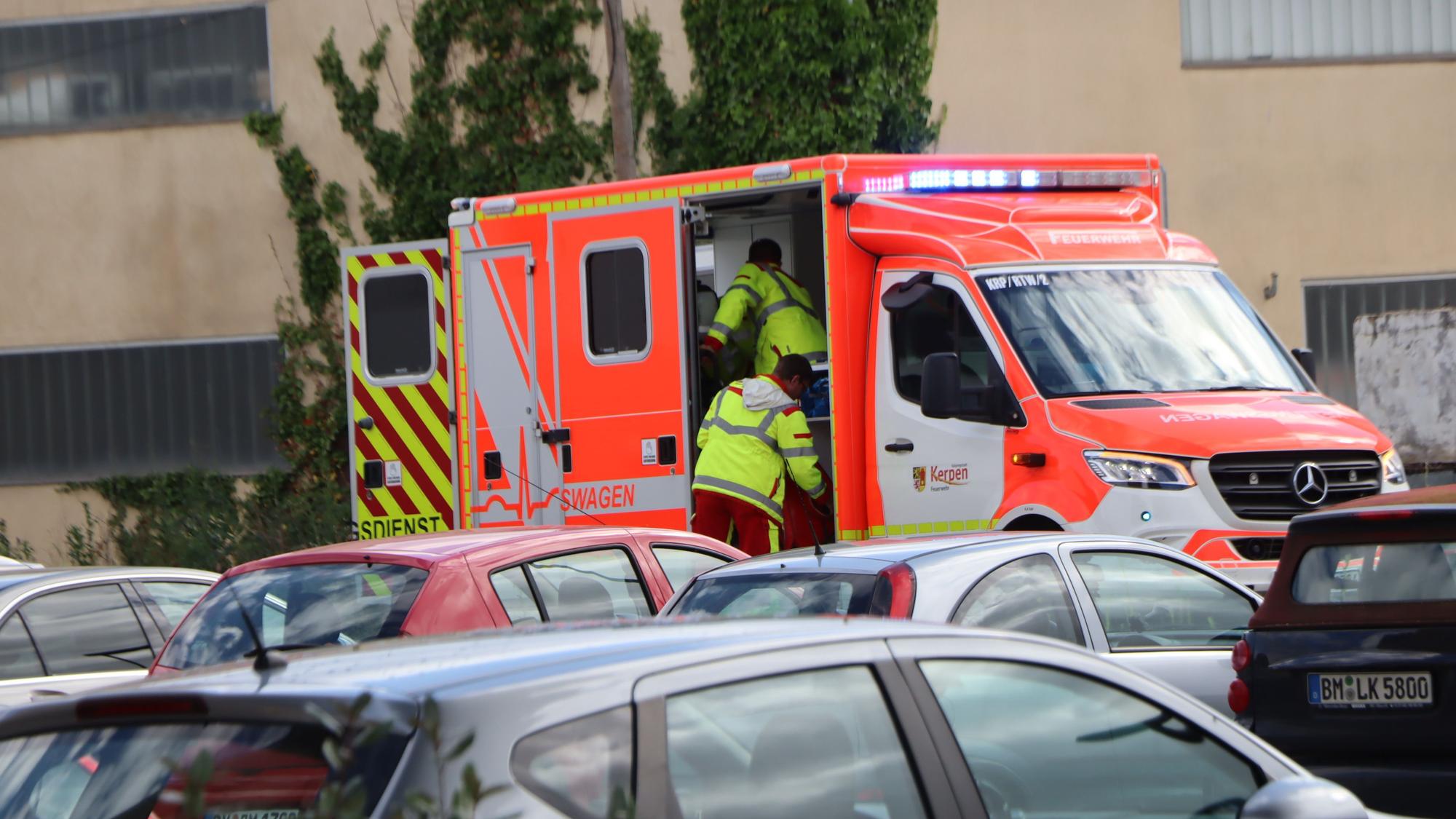 Einsatzkräfte steigen in einen Rettungswagen.