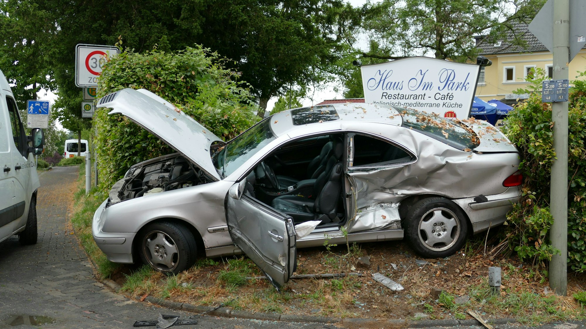 Der zerstörte Mercedes liegt zwischen zwei Hecken.