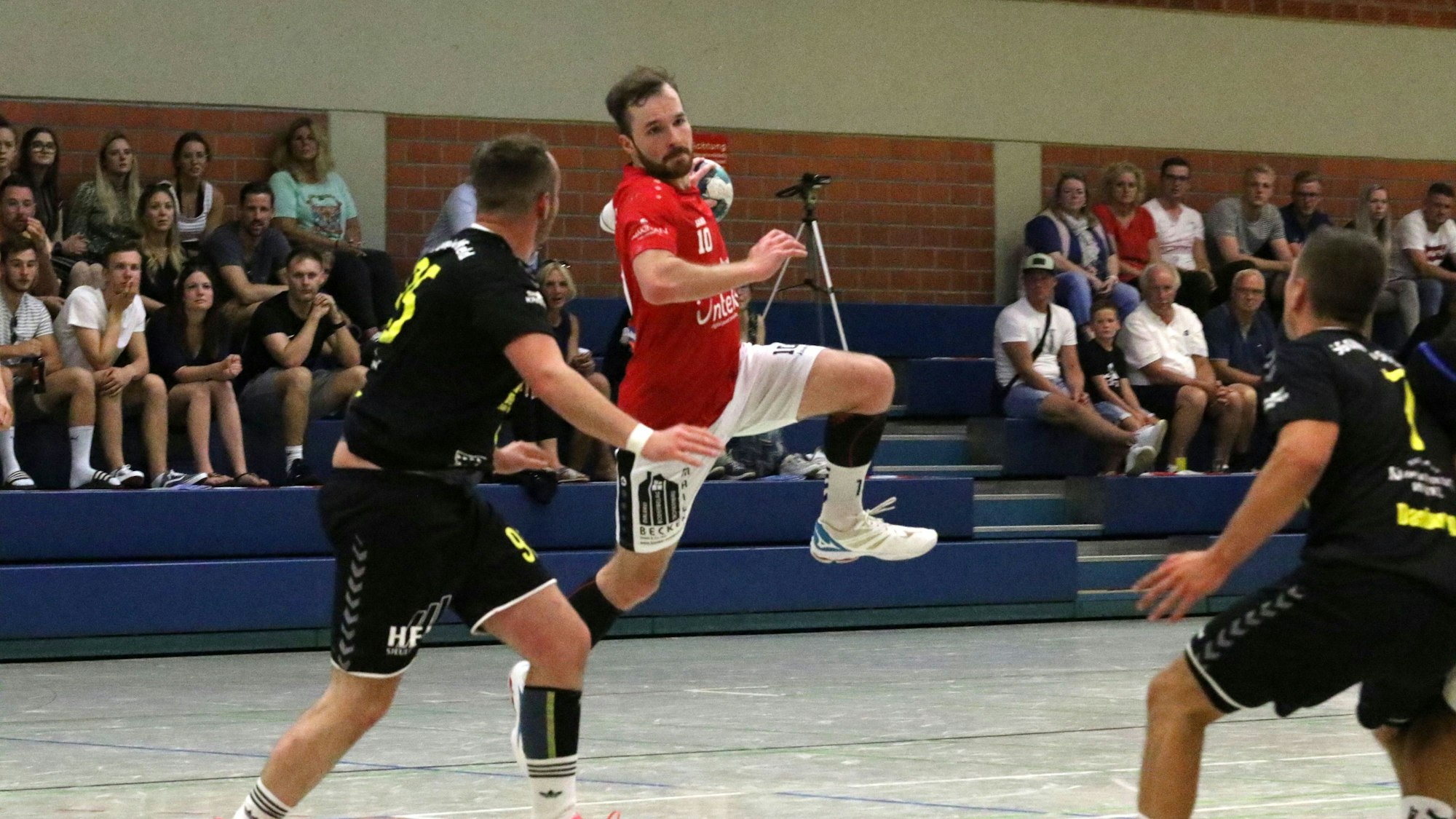 Simon Schöller vom TV Palmersheim setzt, bedrängt von zwei Spielern, zum Wurf an.