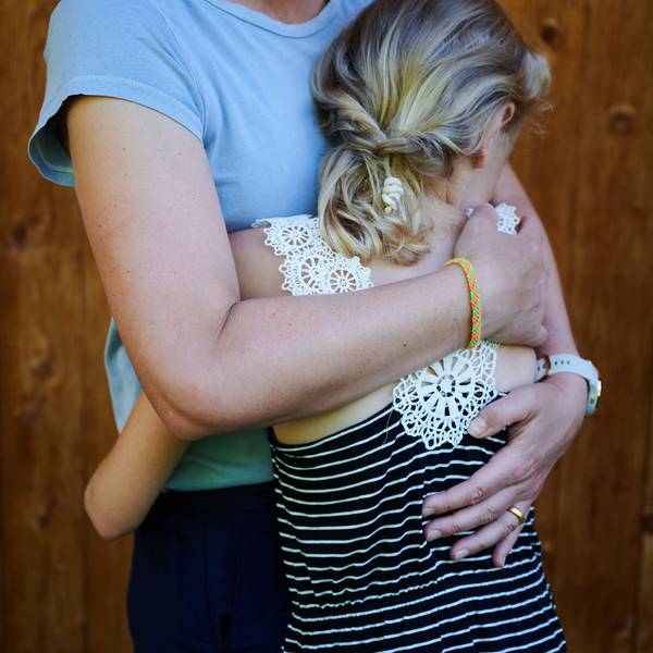 Ein Mädchen wird von seiner Mutter in den Arm genommen und getröstet.